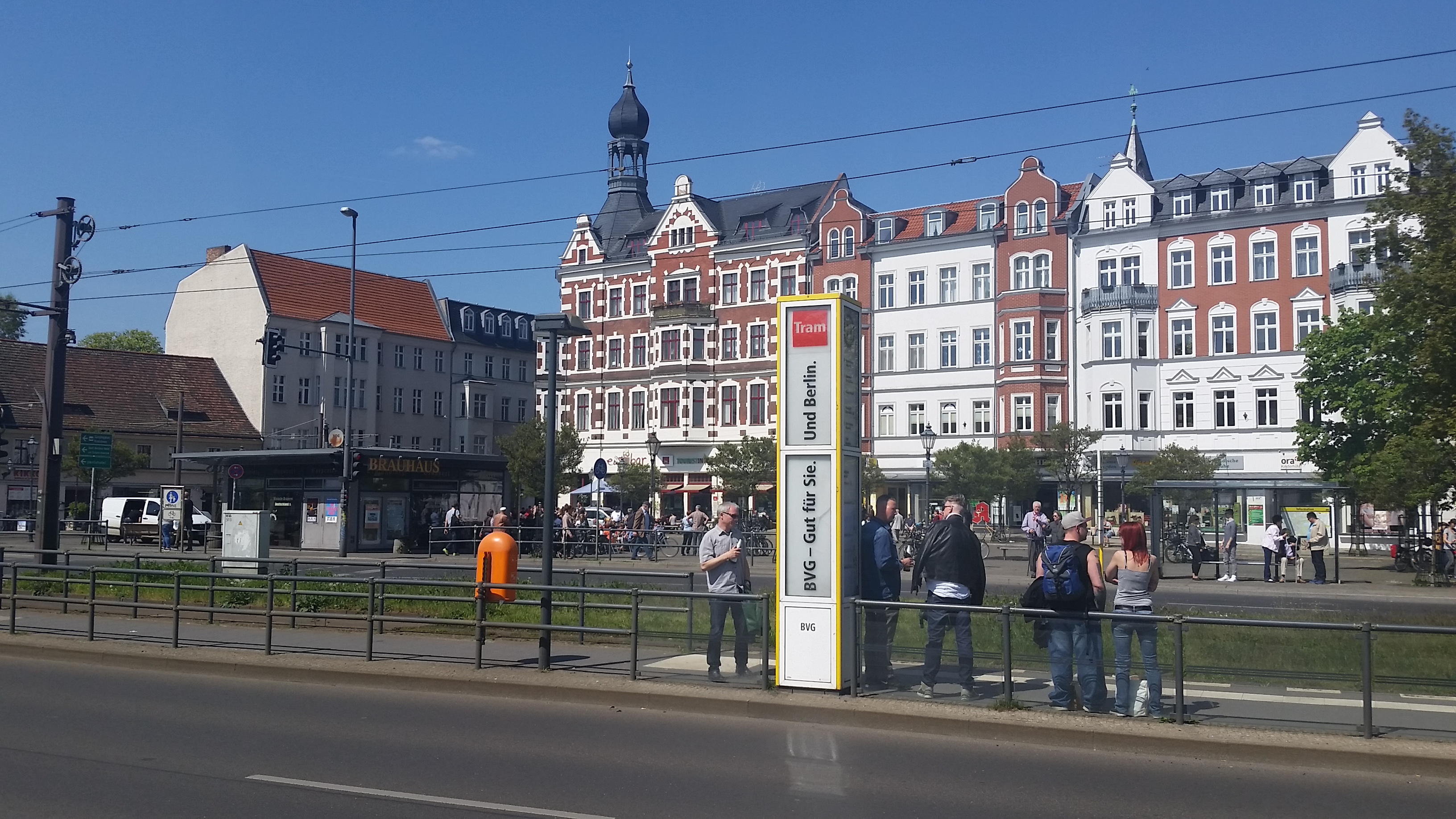 Til venstre Schlossplatzbrauerei Köpenick, som gjør krav på å være Tysklands minste bryggeri. På trikkeholdeplassen et par menn med ølflasker. 